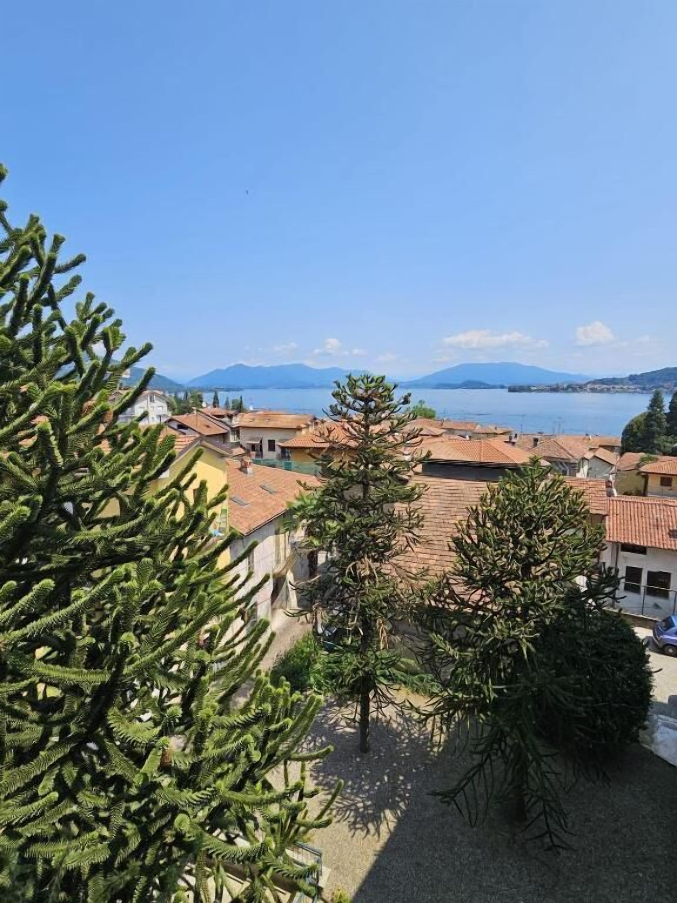 Un quartier résidentiel avec des maisons, un ciel d’un bleu éclatant et des montagnes en arrière-plan.