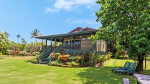 A house with a porch, a staircase, and a lawn with a bench and a picnic table. - Umetsu, Hanalei's Timeless Charm w/ AC TVNC#5096 (Hanalei)