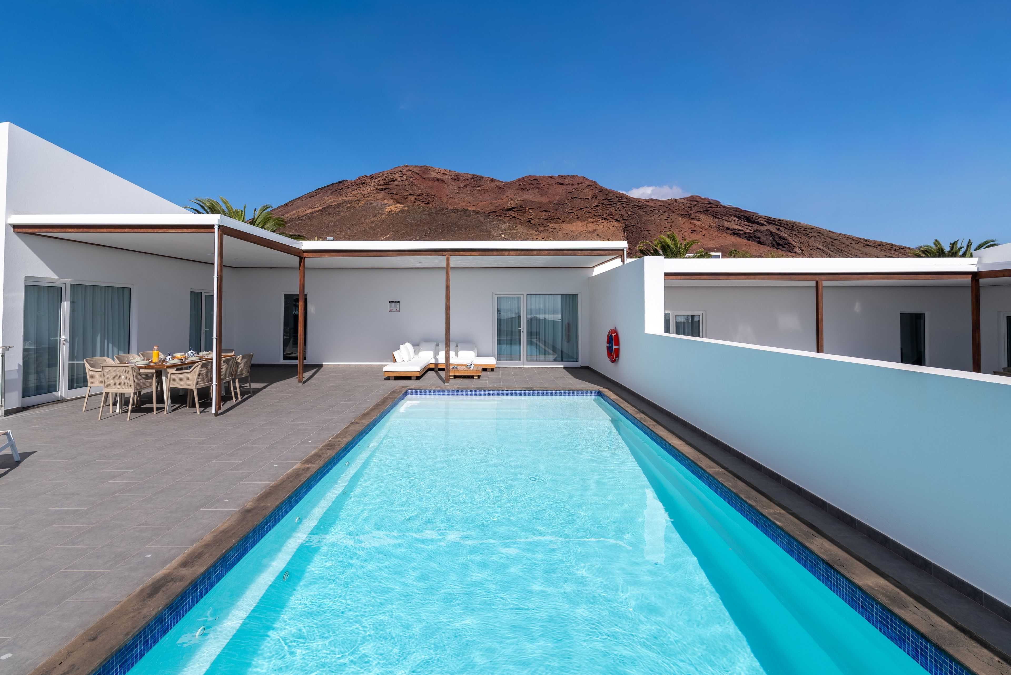 A modern pool area with a clear view of a mountain in the background.