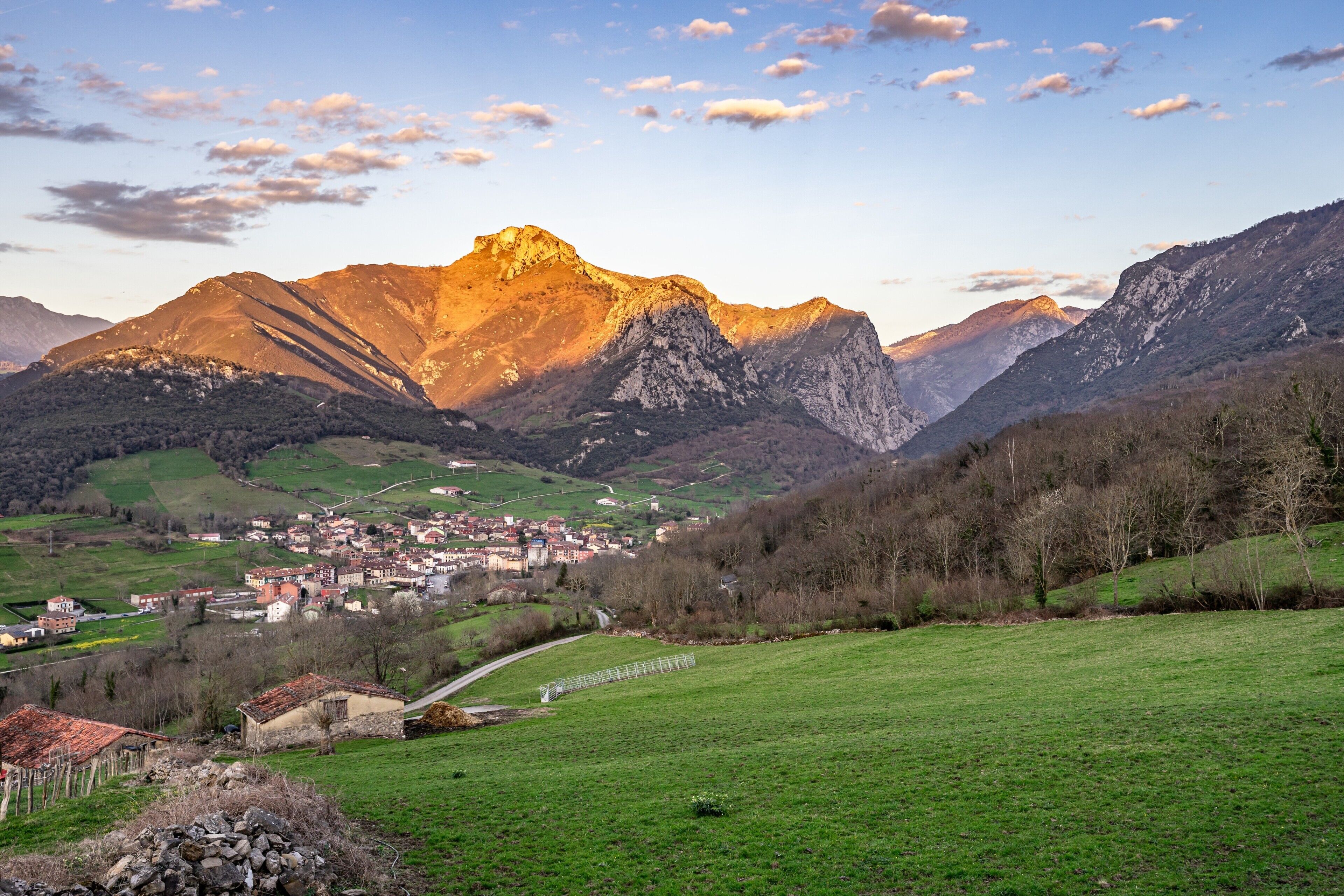 Un paisaje montañoso con un pueblo en el valle.