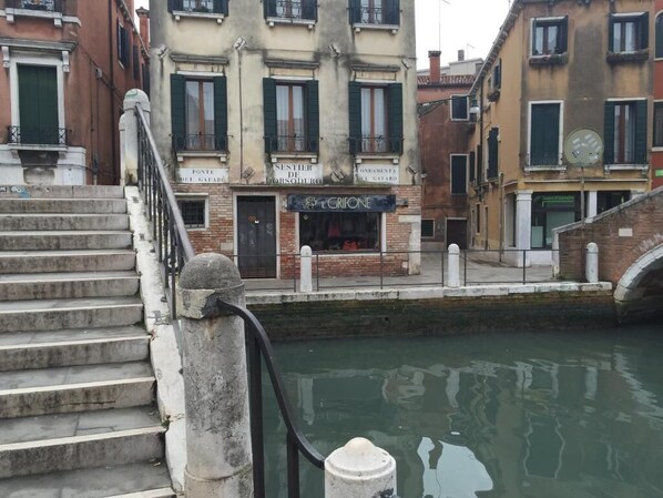 A canal-side building with a sign for 'L'GRIFONE' and a staircase leading to a door. - 2 rooms apart Venice resorts 1 near bus and train (Venezia)