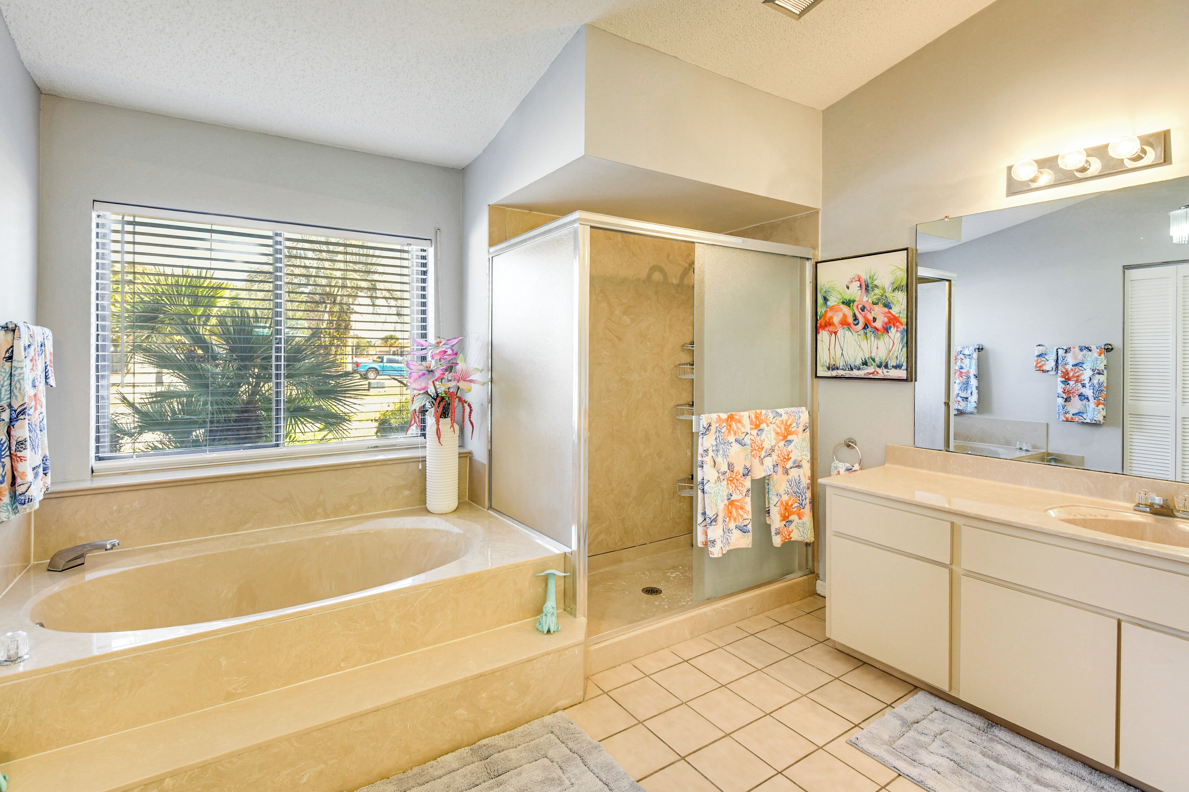 A bathroom with a bathtub, shower, and vanity.