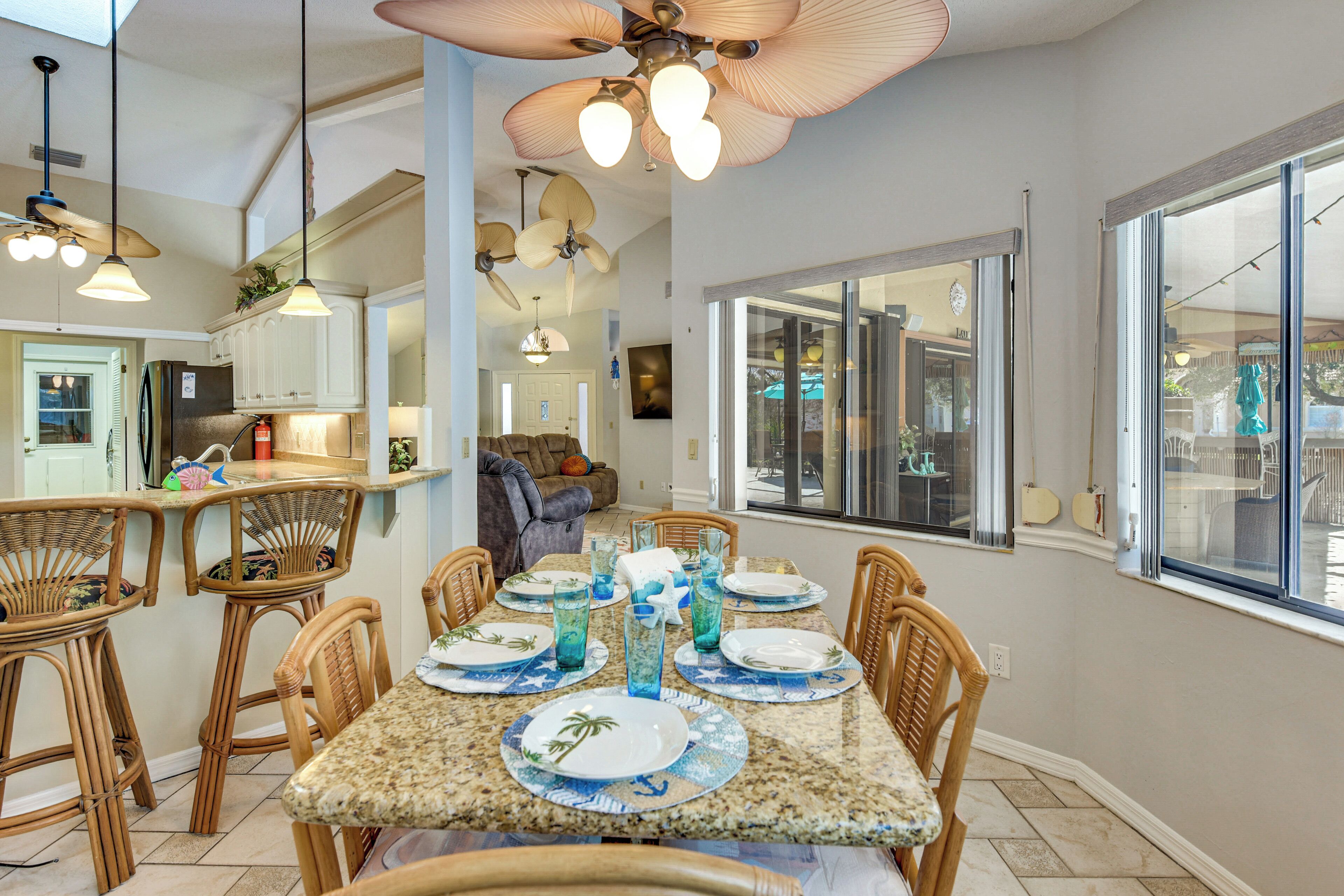 Una cocina amplia con comedor, ventanas grandes y ventiladores de techo.