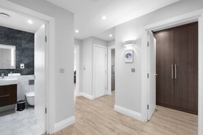 Een moderne badkamer met een marmeren wand, een wastafel en een toilet.