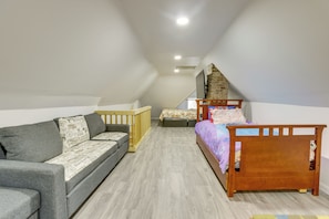 A room with a loft bed, a sofa, a wooden crib, and a television. - Walk to Potomac River! Studio w/ Shared Sauna (Westernport)