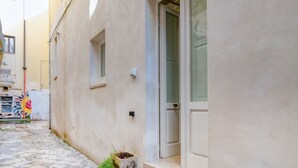 A narrow alleyway with a building featuring a door and windows. - Antony Suite Strada Apartment with Wi-Fi and Air Conditioning (Lecce)