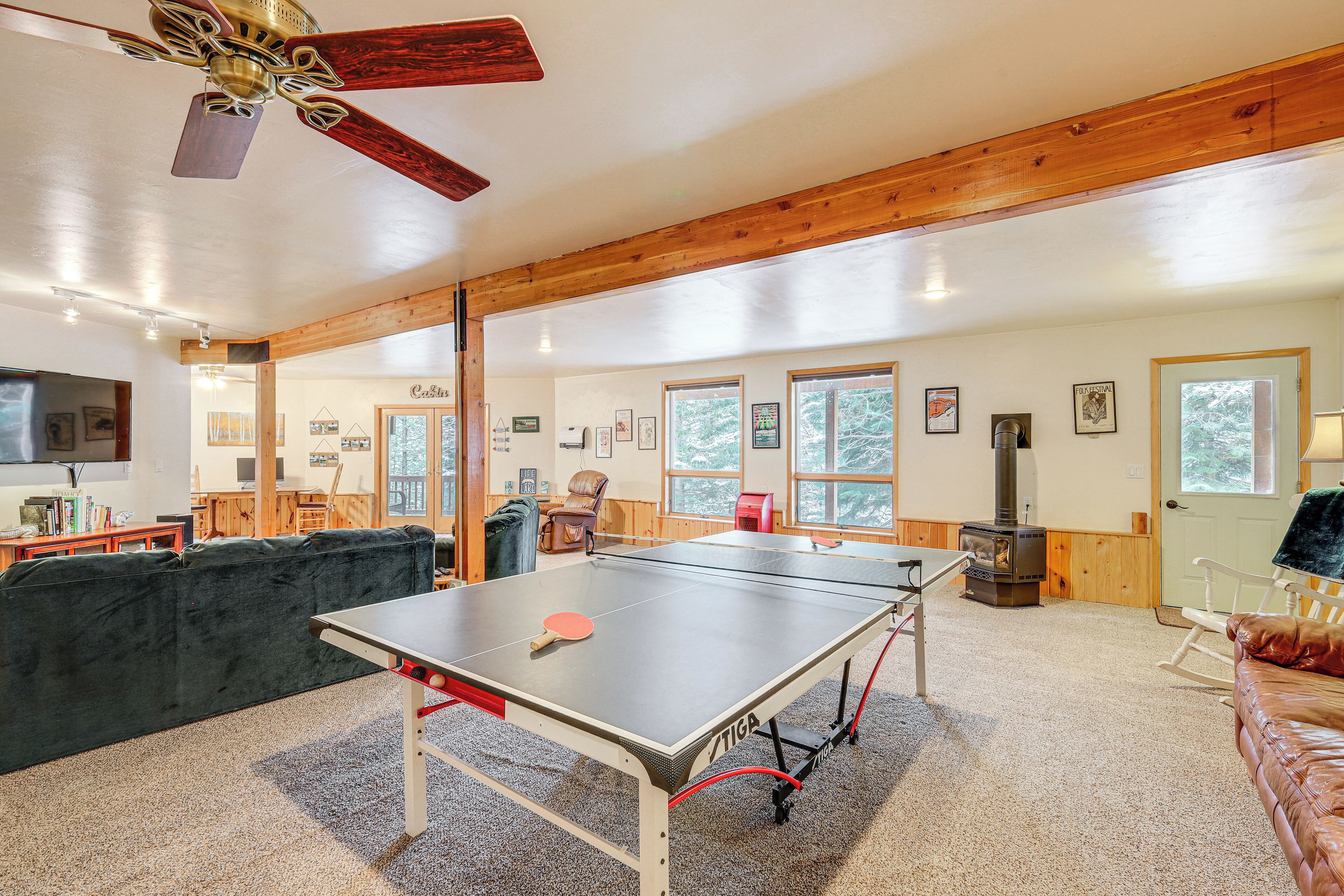 A spacious room with a ping pong table, a fireplace, and a cozy seating area.