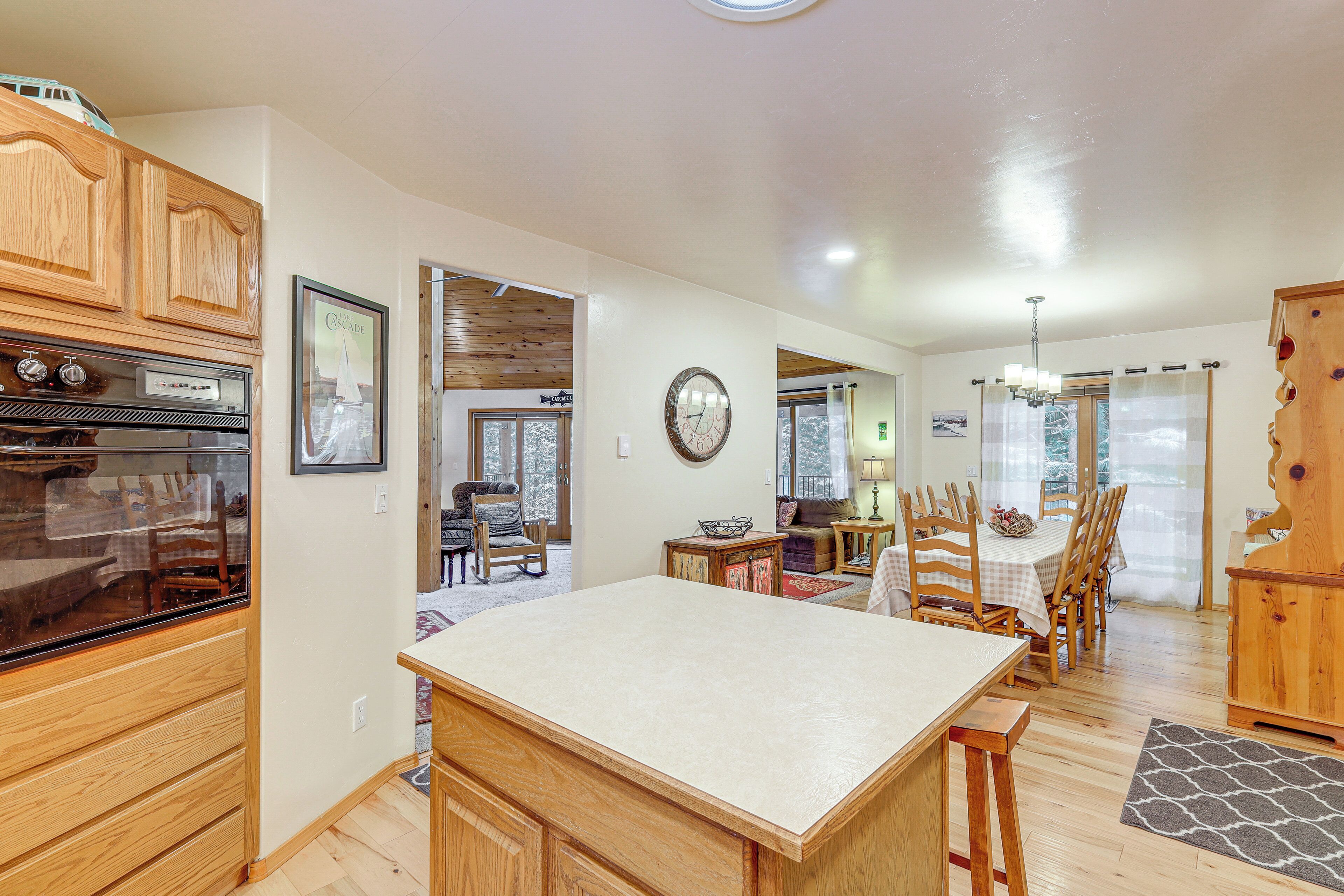 A spacious kitchen with wooden cabinets, a large island, and a dining area with chairs and a table.