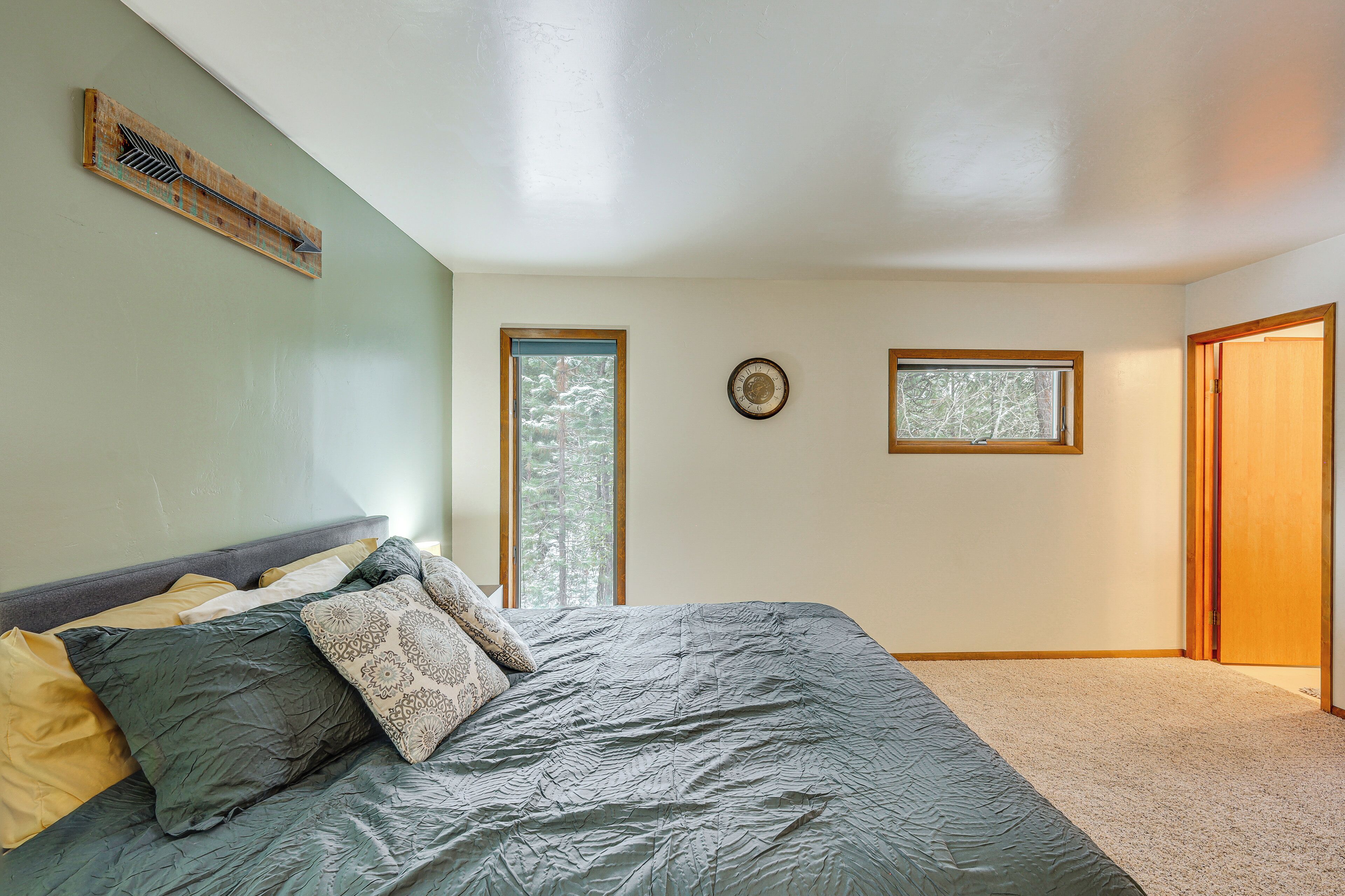 Une chambre à coucher avec un lit, une fenêtre, une porte et un ventilateur fixé au mur.