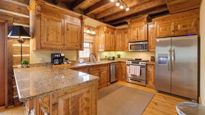 A kitchen with wooden cabinets, granite countertops, stainless steel appliances, and a large island. - Luxury Mountain Retreat w/ Hot Tub in Franklin! (Franklin)