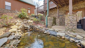 A stone building with a wooden deck and a small stream. - Luxury Mountain Retreat w/ Hot Tub in Franklin! (Franklin)
