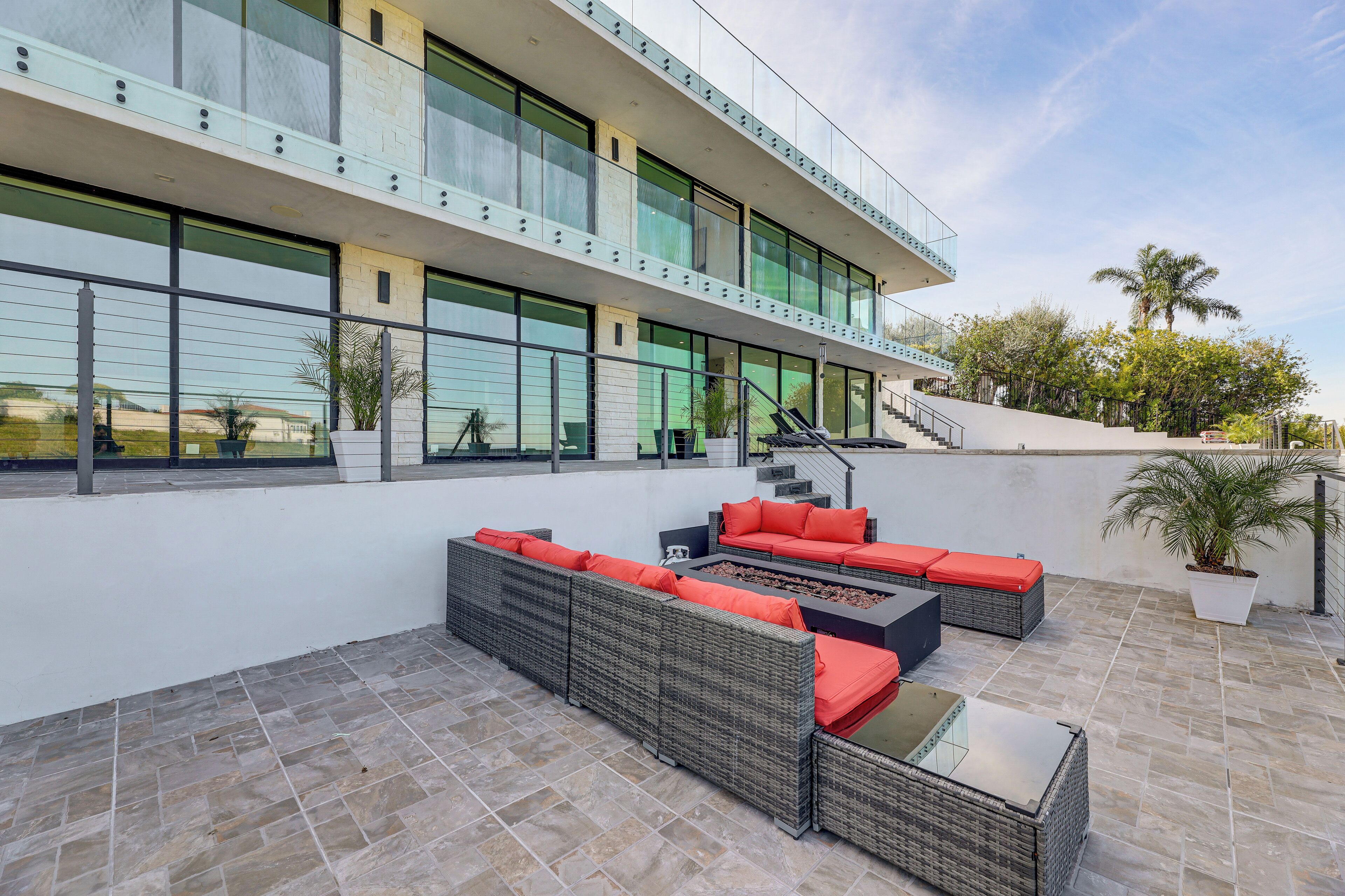 Een modern gebouw met een terras op het dak, compleet met buitenmeubilair en een trap.