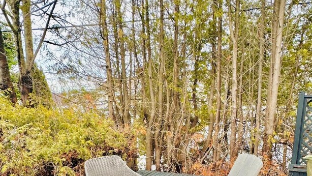 A wooden deck with wicker furniture and a small round table.