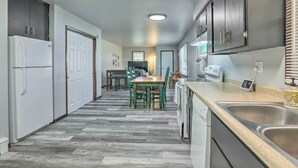 Eine moderne Küche mit einem Holztisch, Einbaugeräten und einer Spüle aus Edelstahl.