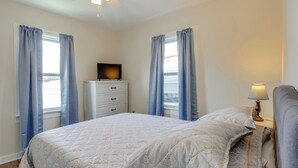 A bedroom with a bed, a dresser, a TV, and a lamp. - Lakes, Whiskey & More! Charming Home in Tullahoma (Tullahoma)