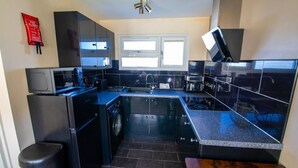 Una cocina compacta equipada con microondas, estufa, fregadero y lavavajillas.