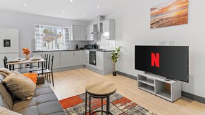 Una sala de estar moderna con un sofá, una mesa de centro y un televisor de pantalla plana.