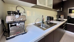 Eine moderne Küche mit Kaffeemaschine, Spüle und Herd.