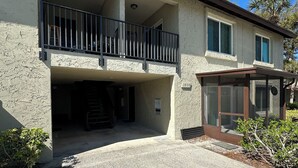 A two-story building with a balcony, a covered entryway, and a driveway. - 1/1 Beautiful Condo/15 mins to Clearwater beach/Peaceful neighborhood/With pools (Clearwater)