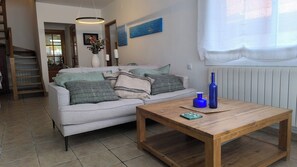A living room with a sofa, a wooden coffee table, and a vase.