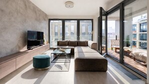 Ein modernes Wohnzimmer mit einer großen Couch, einem Couchtisch und einem Fernseher.