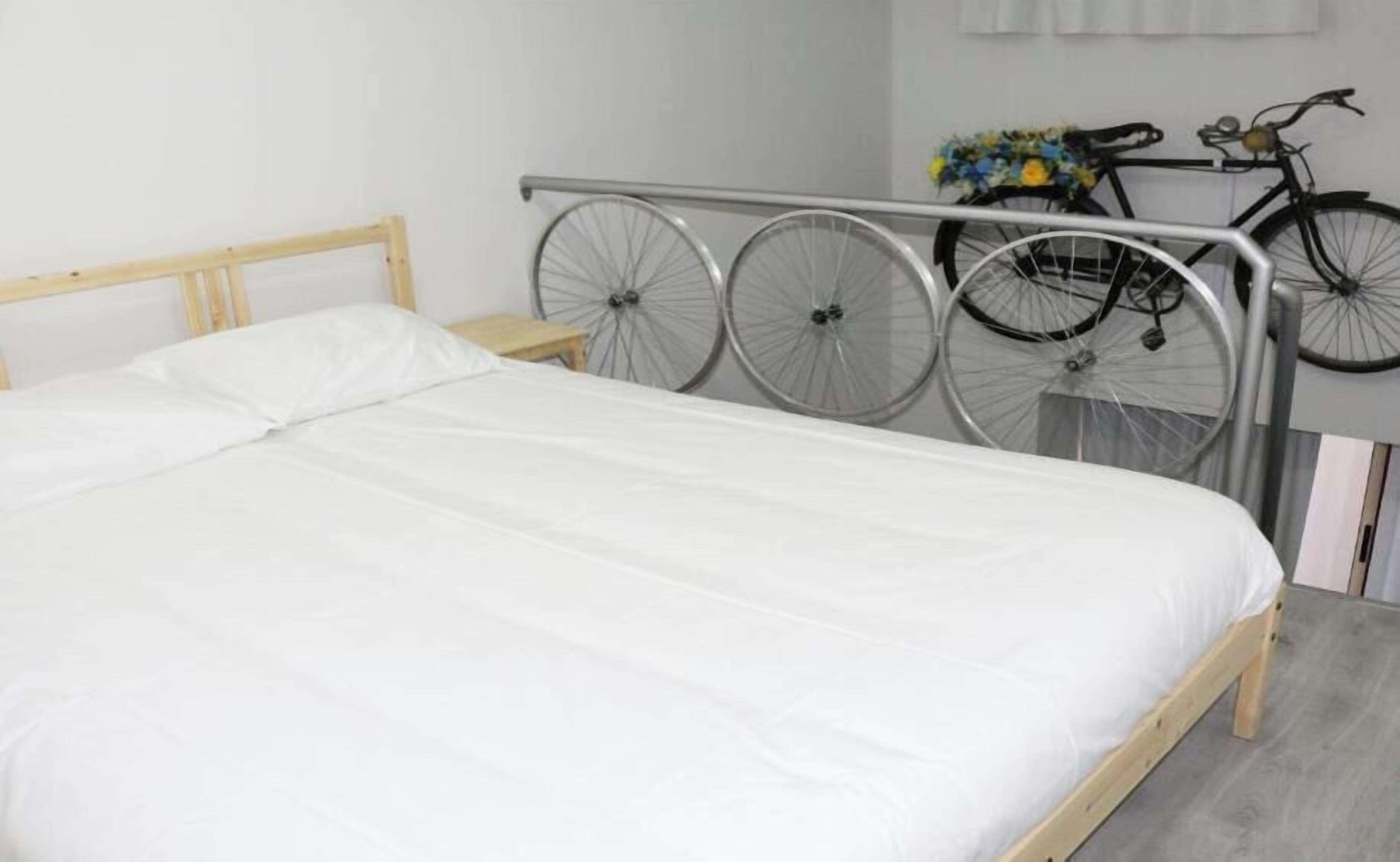 Ein Bett mit Metallkopfteil, Holzrahmen und weißer Matratze.