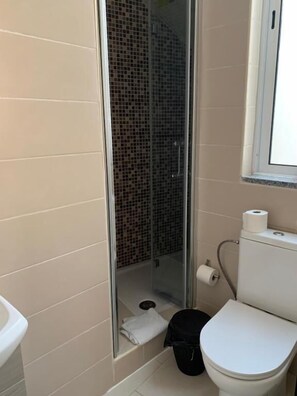 A bathroom with a shower, toilet, and sink. - Vila dos Avós (Figueira da Foz)