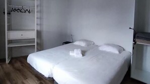 A bedroom with a bed, a wardrobe, and a shelf unit.