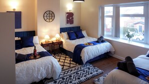 A hotel room with two beds, a large window, and a view of the street. - Near Uni and Hospital - Long Stays - Fast Wi-Fi - 15 Mins to City (Manchester)