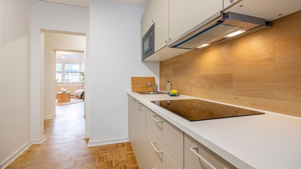 A modern kitchen with a wooden countertop, white cabinets, and a built-in microwave. - New Apartment, 5 Minutes to Centro and Gasometer (Oberhausen)