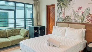 A hotel room with a bed, a sofa, a small cabinet, and a window with curtains. - The Town  (El Nido)