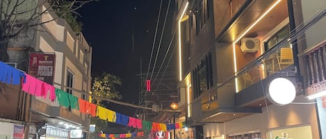 A bustling street scene at night with people walking and shops on either side.