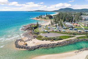 An aerial view of a coastal resort with a beach, parking area, and buildings. - Kokomo Right in the Heart of South West Rocks (South west rocks)