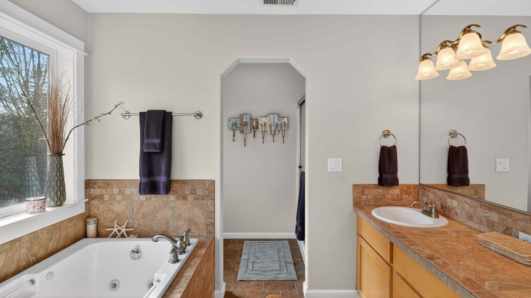 A modern bathroom with a bathtub, a vanity with a sink, and a shower area.