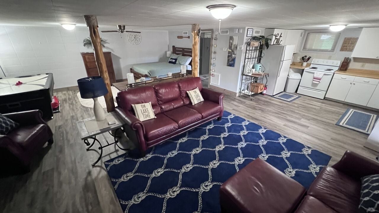 A compact living space with a sofa, a dining table, a kitchen area, and a separate bedroom.
