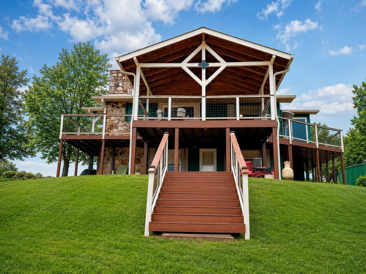 Un edificio a due piani con una scala in legno che conduce a un ingresso coperto.