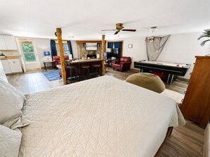 A hotel room with a bed, a dining area with stools, a pool table, and a ceiling fan. - Little Lake Cove 2 Bedroom Home (Sevierville)