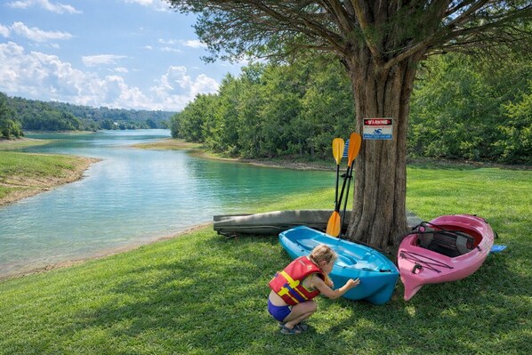 A riverbank with kayaks and a paddle under a tree. - Little Lake Cove 2 Bedroom Home (Sevierville)