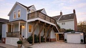 A two-story house with a wooden deck, a garage, and a small shed. - 12 Goodwin Unit 2 1 Bedroom Apts (Newport)