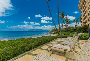 A resort with a pool area, lounge chairs, and a view of the ocean. - Polo Beach Club 703 2 Bedroom Condo (Kihei)