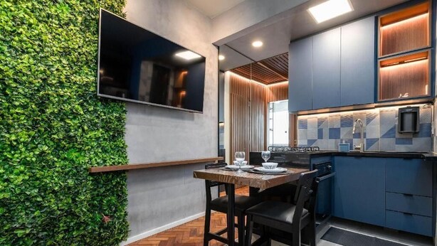 Une cuisine moderne avec des armoires bleues, un plan de travail en bois et une cuisinière intégrée.
