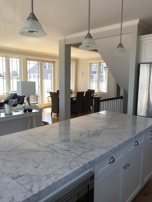 A modern kitchen with marble countertops, white cabinetry, and pendant lighting. - Ocean View Oasis - 3BR/3BA w/ Spacious Deck & Starry Night Dining (York)