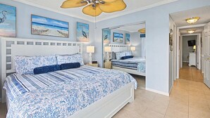A bedroom with a large bed, a ceiling fan, and artwork on the walls. - New Listing! Third Floor Condo Close to Beach With Pool Views. (Saint Augustine)