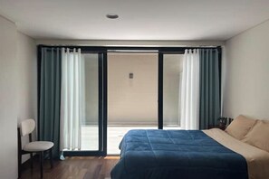 A bedroom with a bed, a chair, and a sliding glass door leading to an outdoor area. - Modern and cozy studio apartment in La Paz (La Paz)