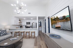 Ein modernes Interieur mit Küche, Essbereich und einem großen Fernseher, der eine schöne Aussicht zeigt.