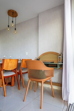A dining area with wooden chairs, a table, and hanging light fixtures. - Lightness and Comfort: DFPlaza Shopping Águas Claras (Águas Claras)
