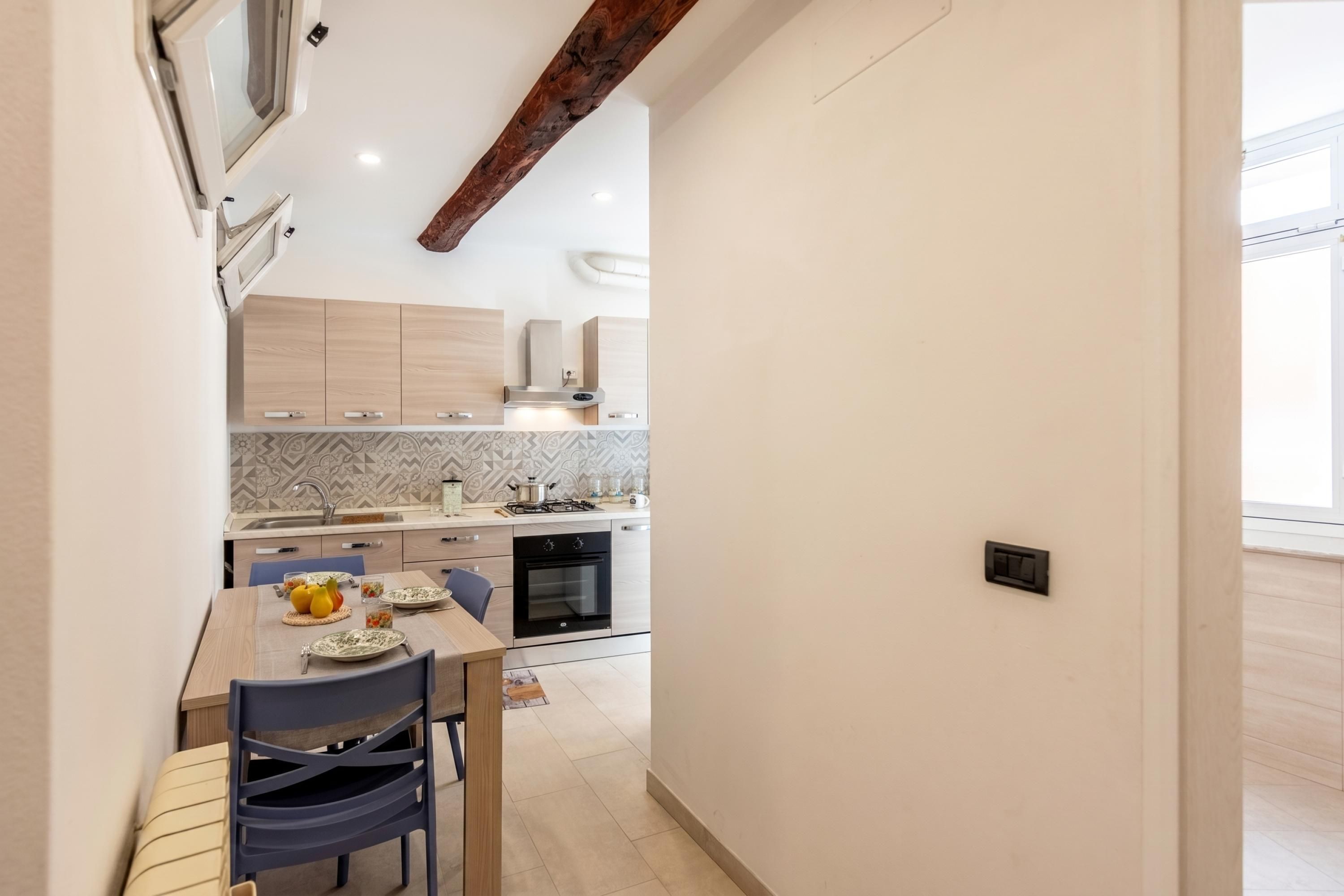 Una cucina moderna con mobili in legno, un tavolo da pranzo con sedie e un forno a incasso.