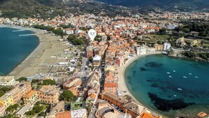 Vista aérea de un pueblo costero con edificios, una playa y una bahía.