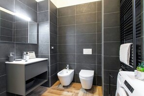 Departamento Deluxe, vista al patio | Baño | Regadera, secadora de cabello, toallas, jabón 