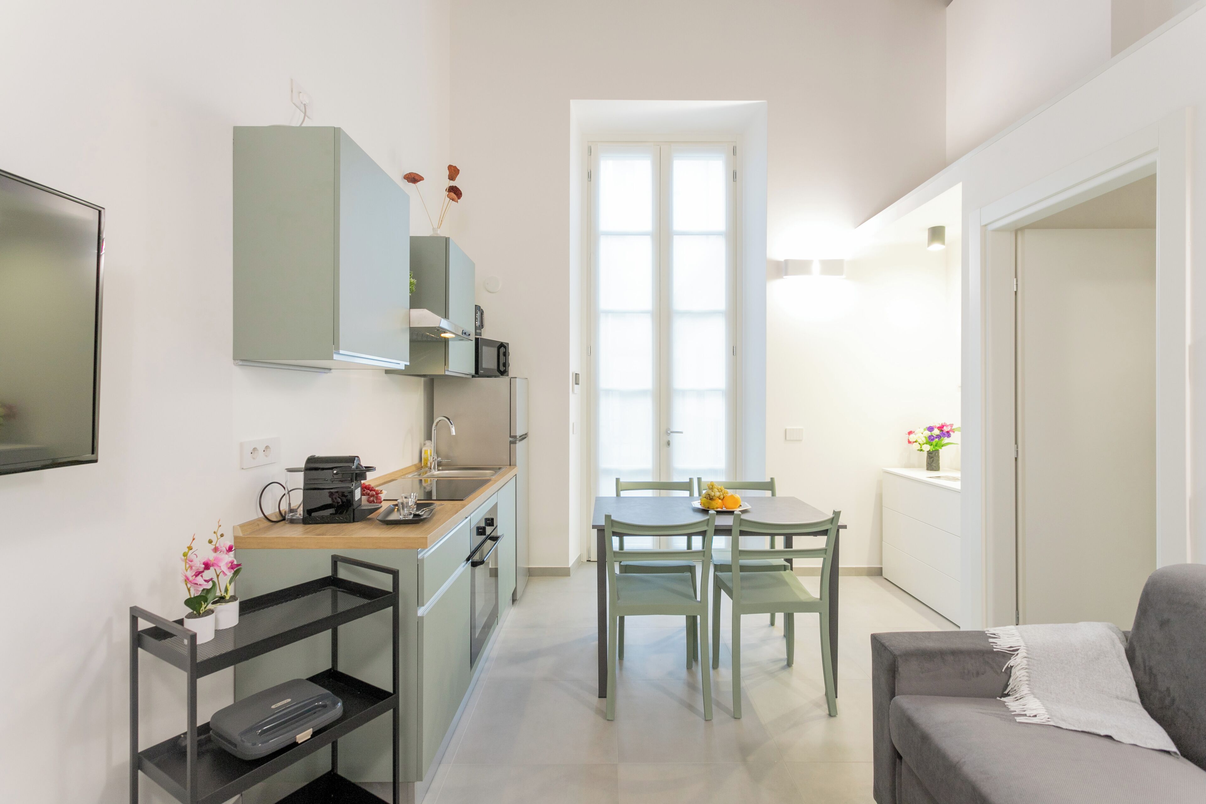Um espaço compacto com cozinha compacta, área de refeições e sofá.